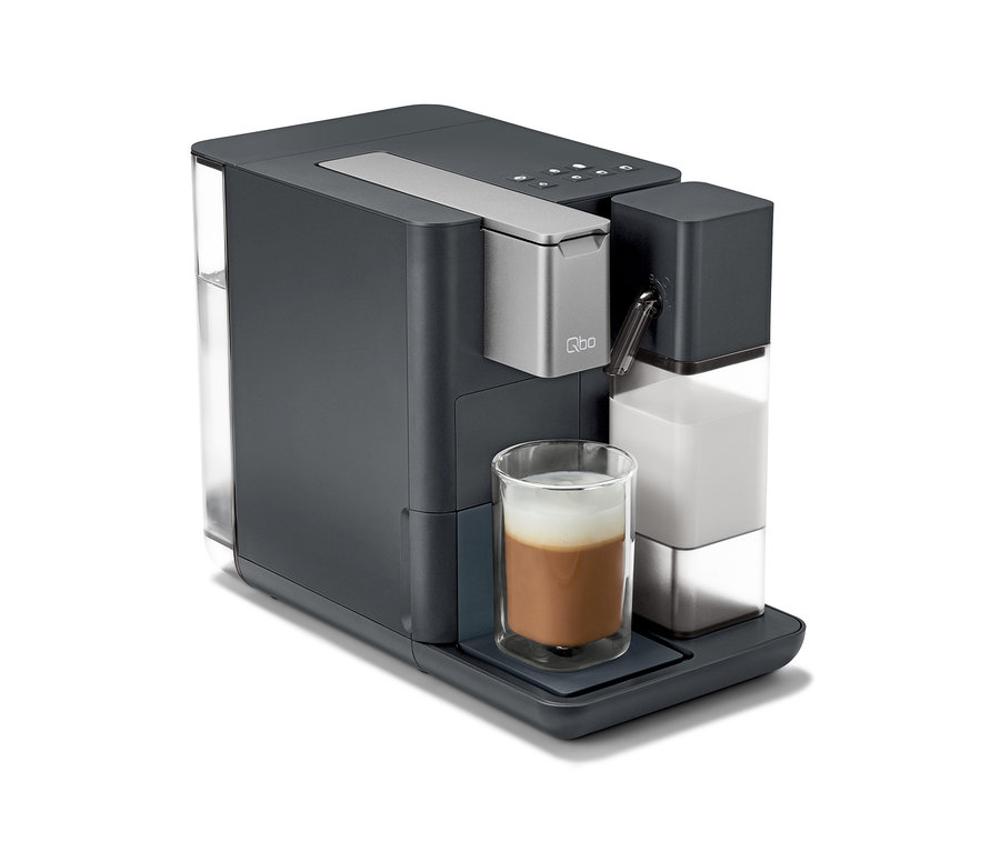 Graue Qbo MILK MASTER Kaffeemaschine mit in ein Glas gegossener Milch.