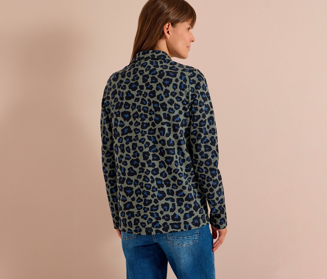 Frau von hinten, trägt einen CECIL Jerseyblazer mit Leopardenmuster in Grün, Schwarz und Blau und blaue Jeans.