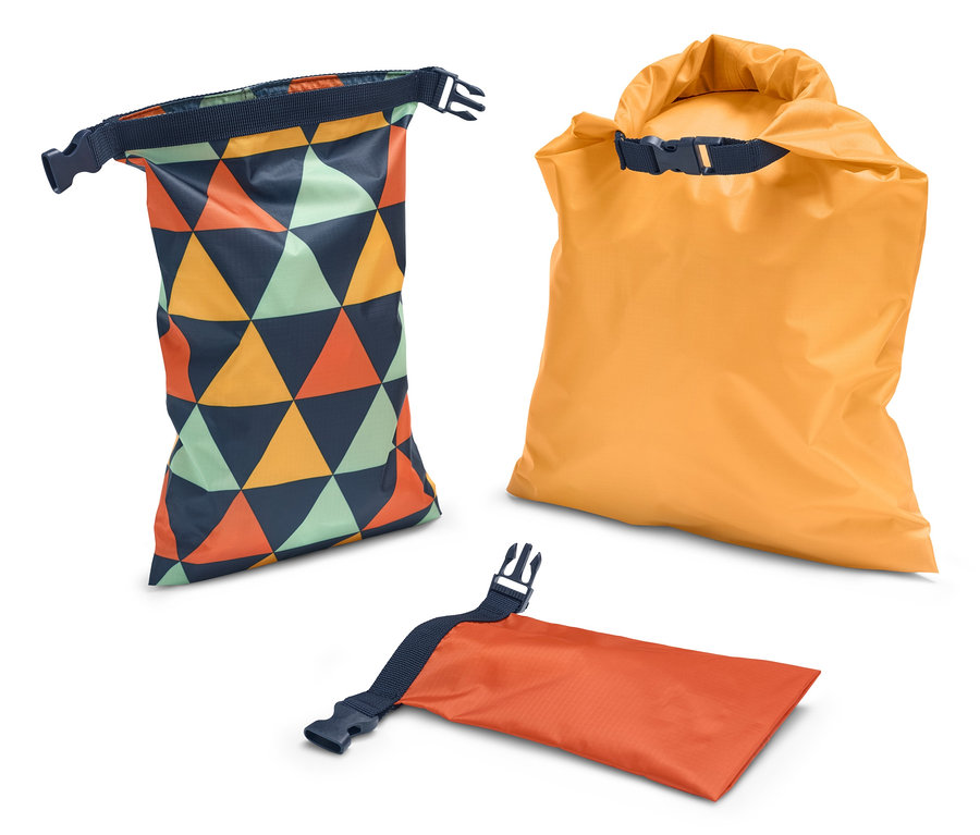 Drei wasserfeste Packsäcke: Einer mit geometrischem Muster, einer orange gerollt und einer orange flach liegend.