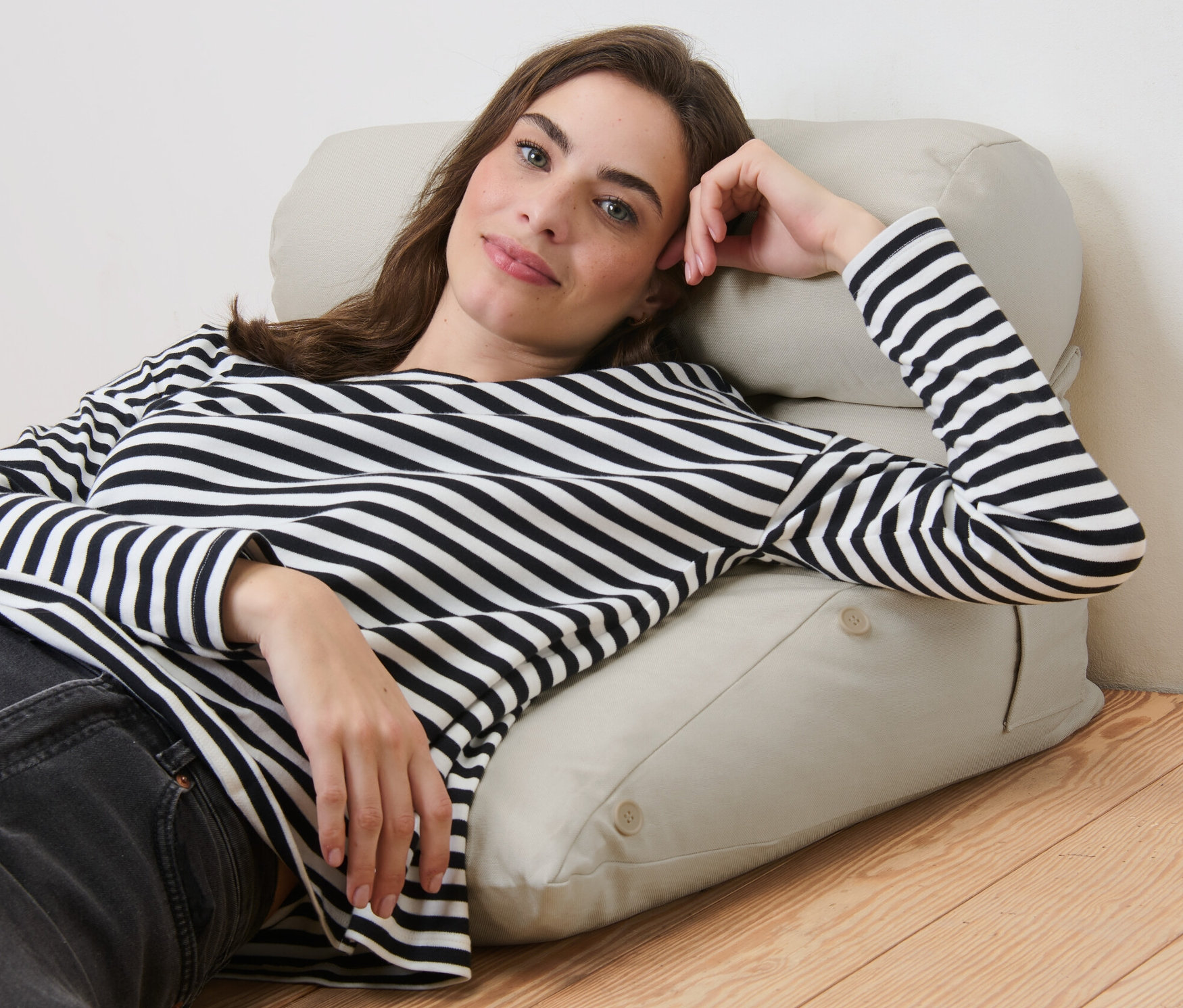 Frau liegt auf einem Keilkissen.