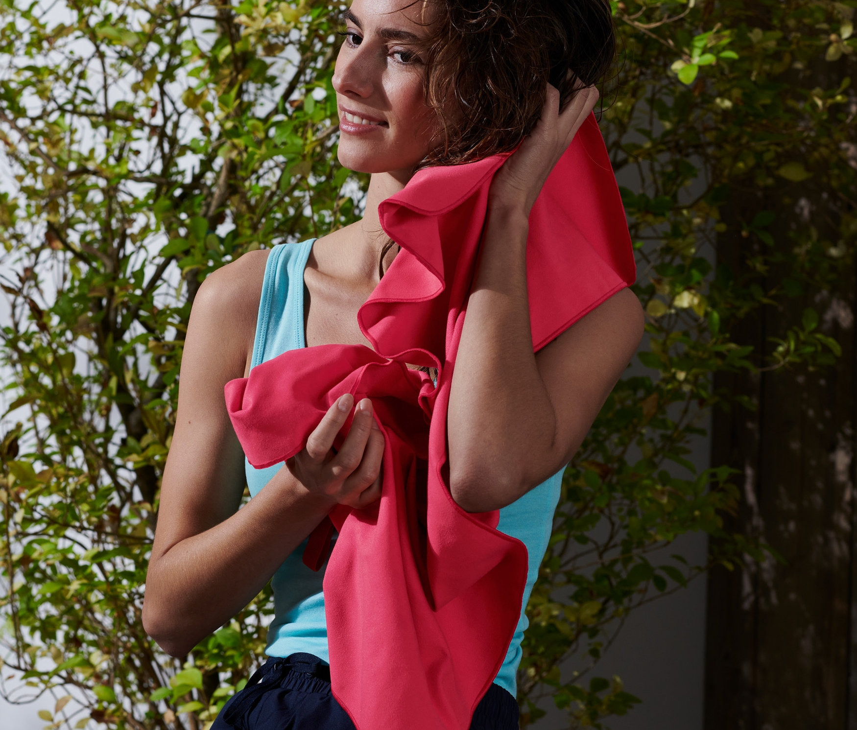 Frau trocknet ihre Haare mit einem Outdoor-Handtuch, ca. 50 x 100 cm.