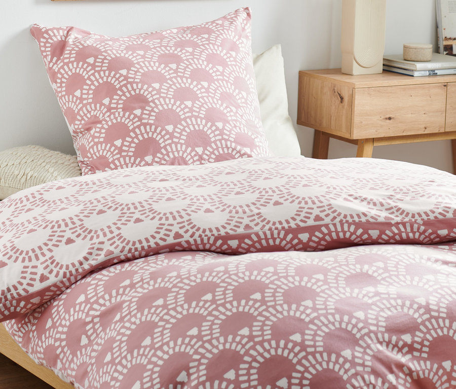 Jersey-Bettwäsche in Normalgröße mit geometrischem Muster auf einem Bett.