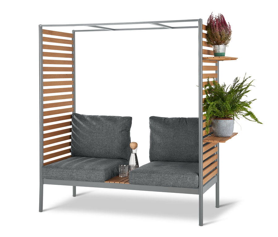 Graue ScanCom Outdoor-Lounge mit Fußhocker und zwei Pflanzen.