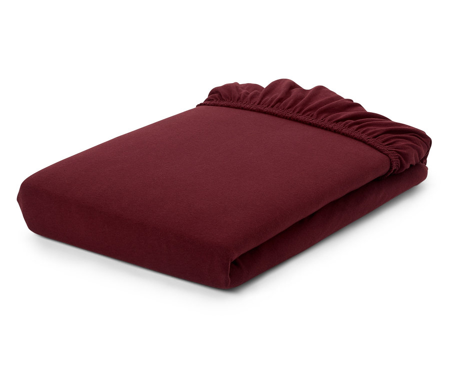 Ein burgunderrotes Spannbettlaken, gefaltet auf einem weißen Hintergrund.