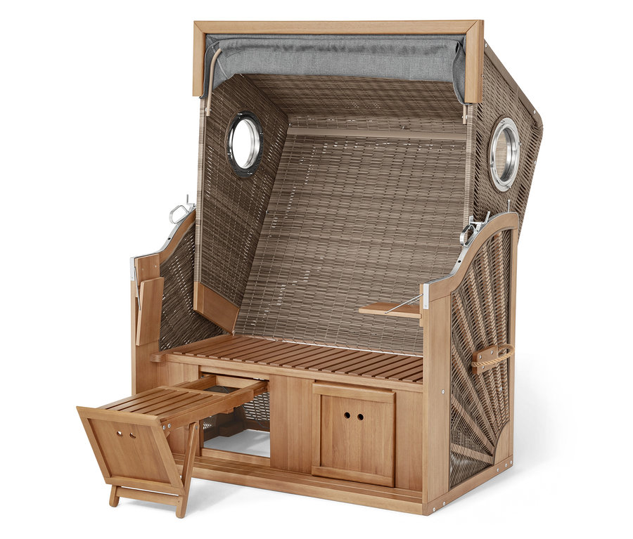 Strandkorb aus Korbgeflecht mit Holzrahmen, ausklappbarer Fußstütze und zwei Bullaugen.