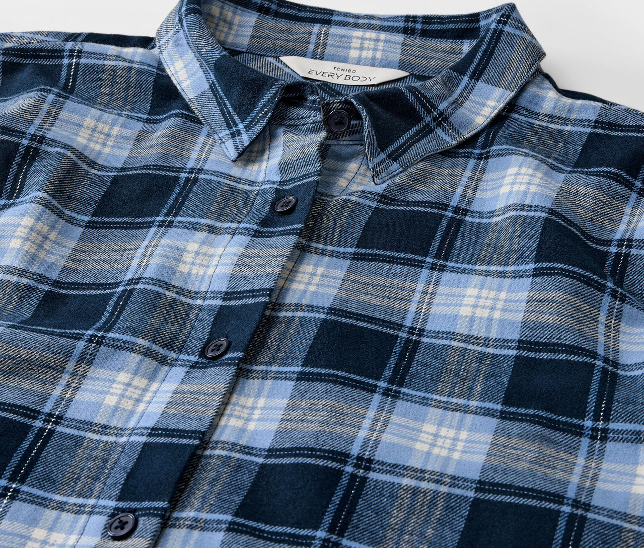 Detailaufnahme eines blau karierten Hemdes.