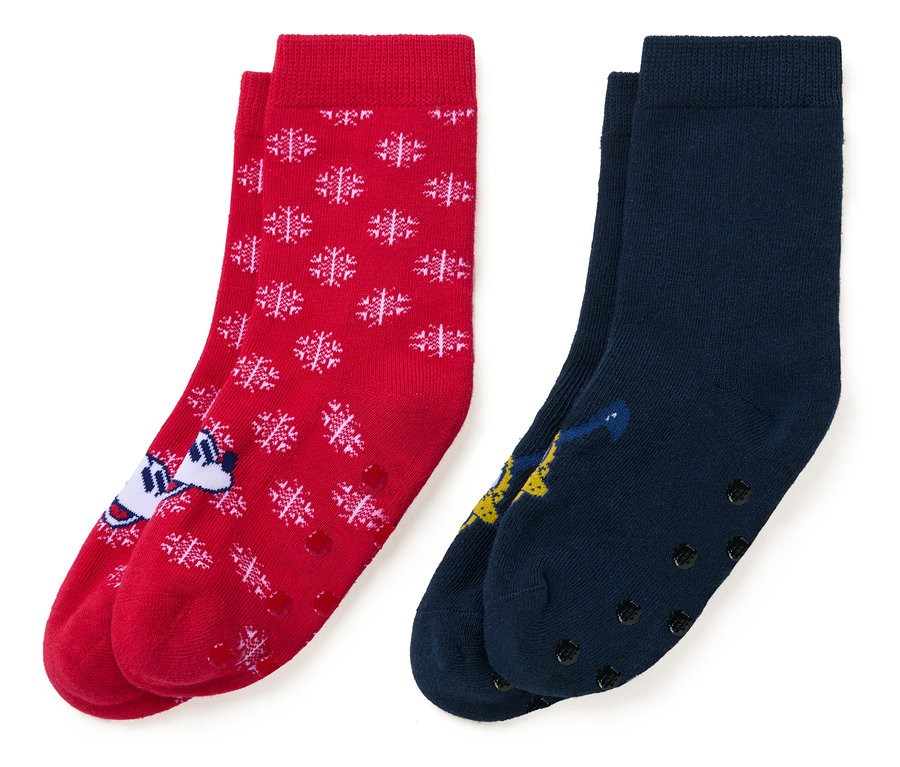 Zwei Paar Socken: rot mit weißen Schneeflocken und einer Zeichentrickfigur, und dunkelblau mit einer Zeichentrickfigur.