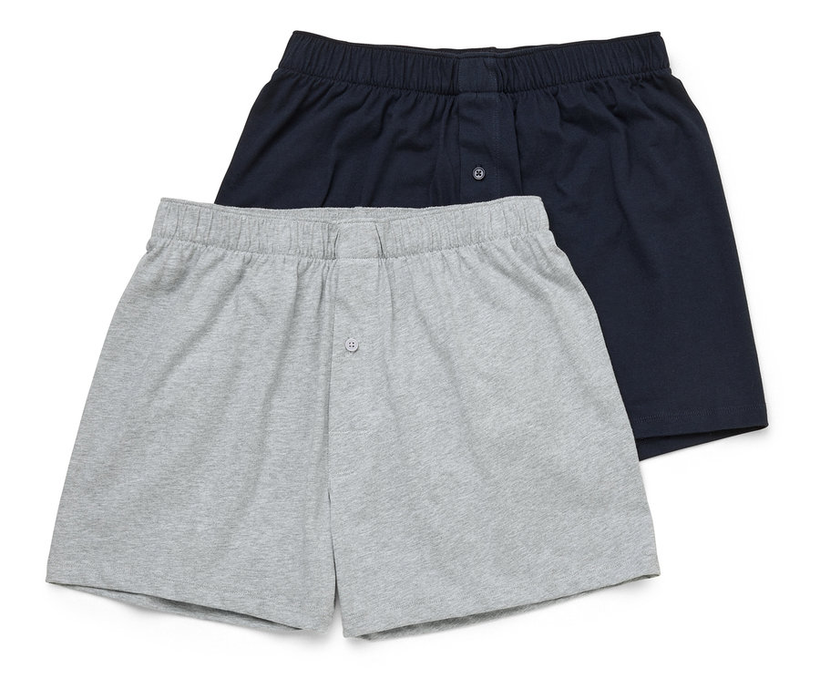 Zwei Boxershorts, eine marineblau und eine grau, liegen übereinander.