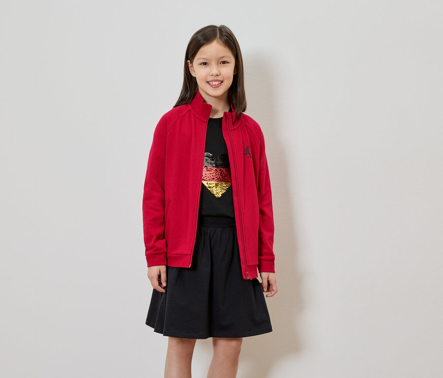 Mädchen mit roter Jacke, schwarzem Rock und T-Shirt mit Deutschland-Herz