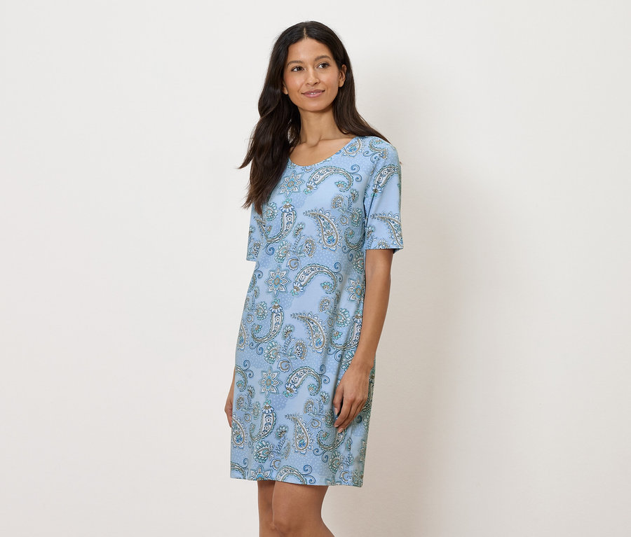 Frau trägt blaues Kleid mit Paisley-Muster.