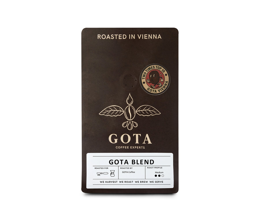 Dunkelbraune Packung Gota Coffee Gota Blend Ganze Bohne mit geflügeltem Kaffeebohnen-Logo und Aufschrift „ROASTED IN VIENNA“.