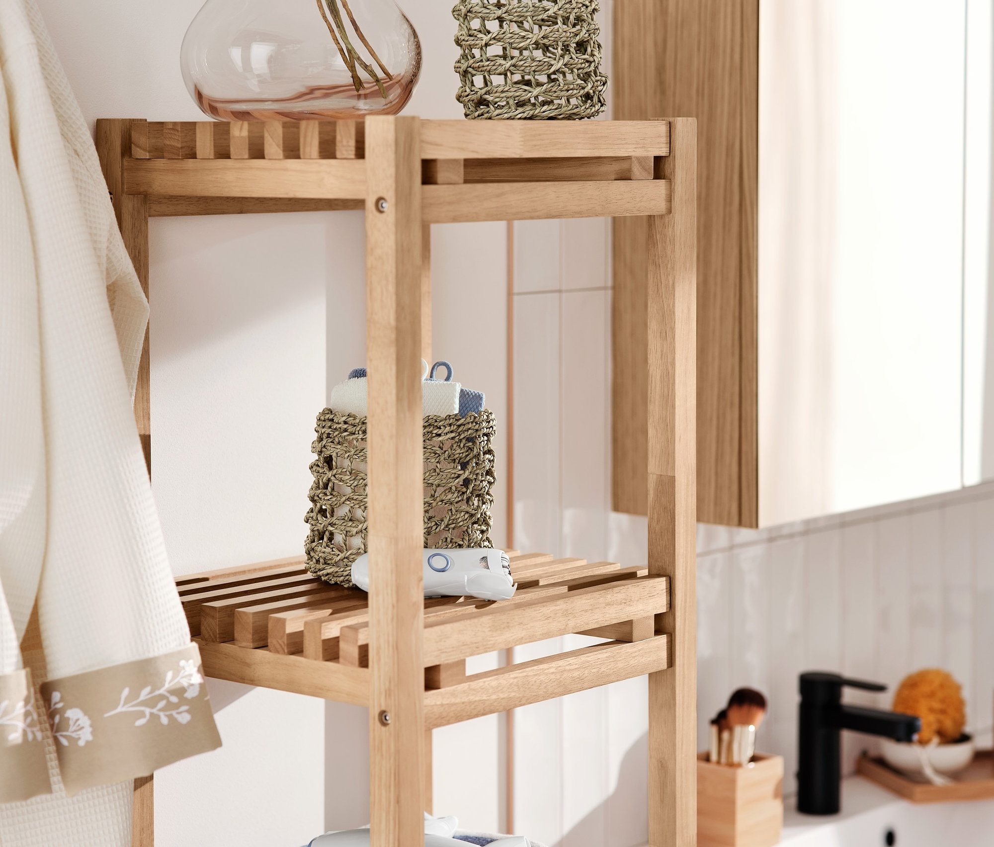 Schmales Standregal mit 2 Aufbewahrungskörben, Badetuch, Gesichtsepilierer und Haartrockner- und Glätteisen-Travelset.