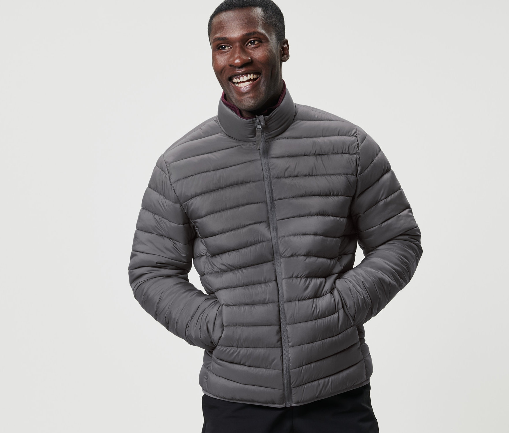 Ein lächelnder Mann posiert in einer verstaubaren Steppjacke.