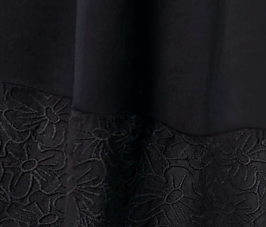 Detailansicht eines Webkleids mit Stickerei.