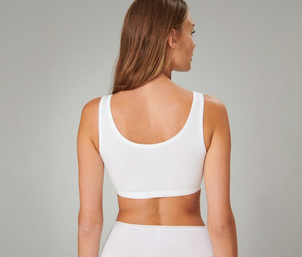 Frau von hinten in einem weißen SCHIESSER Bustier und weißer Unterwäsche.