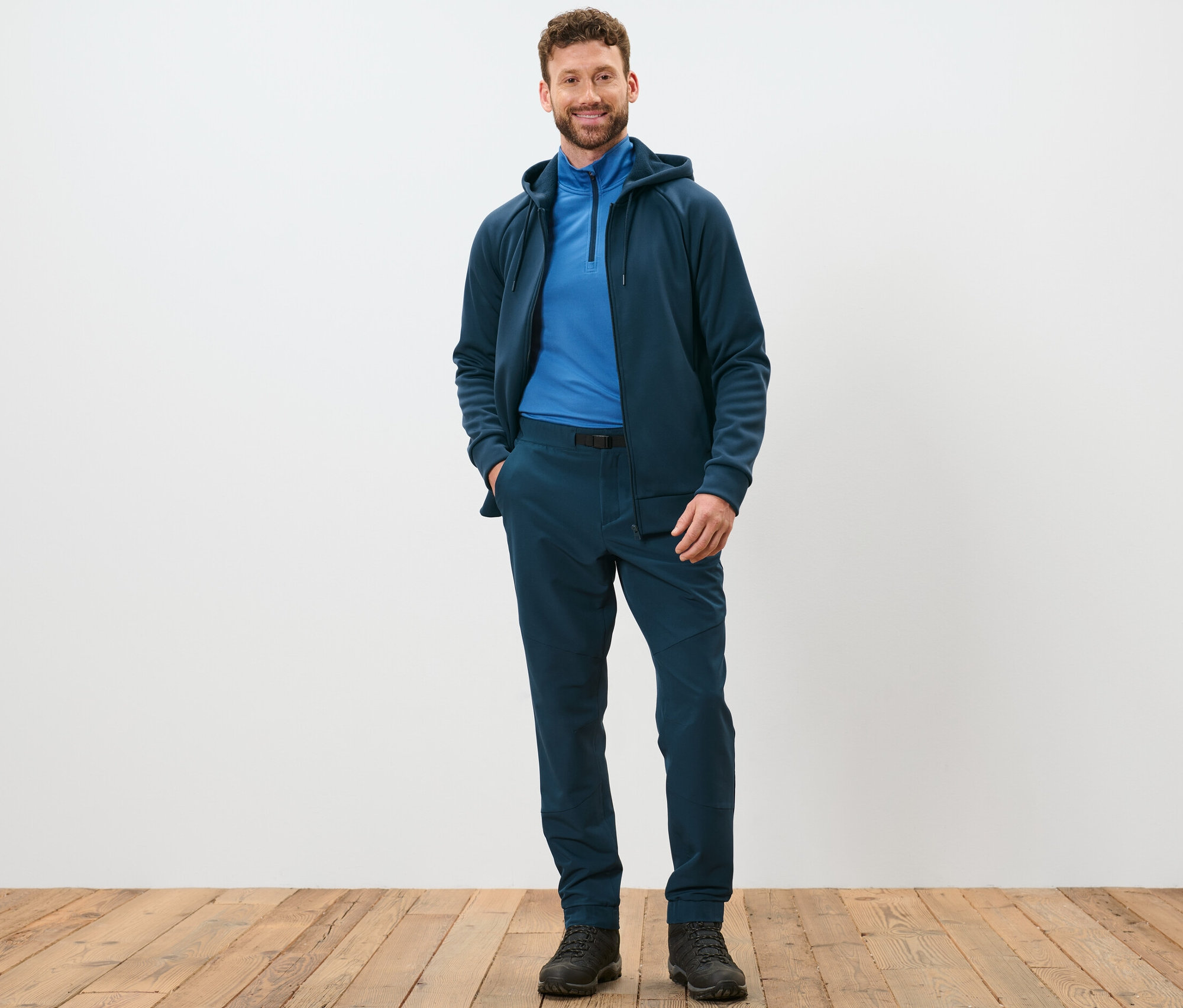 Mann steht und posiert in Thermohose mit Gürtel.