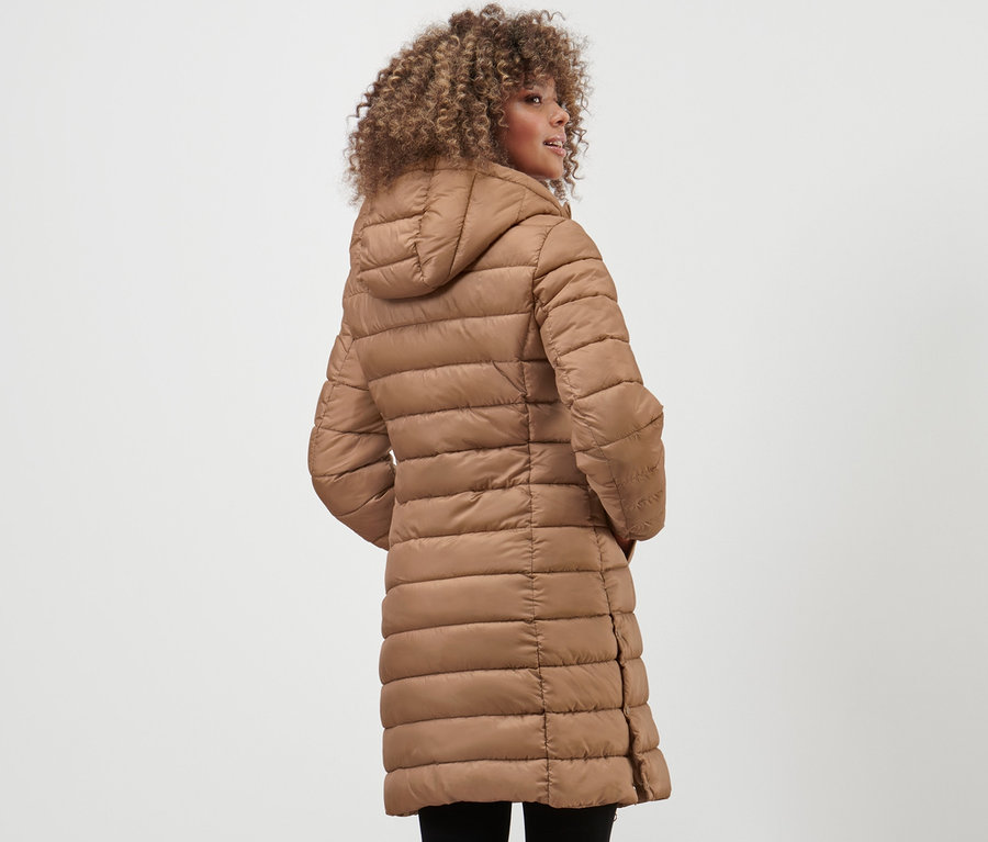 Frau trägt einen Steppmantel mit Kapuze.