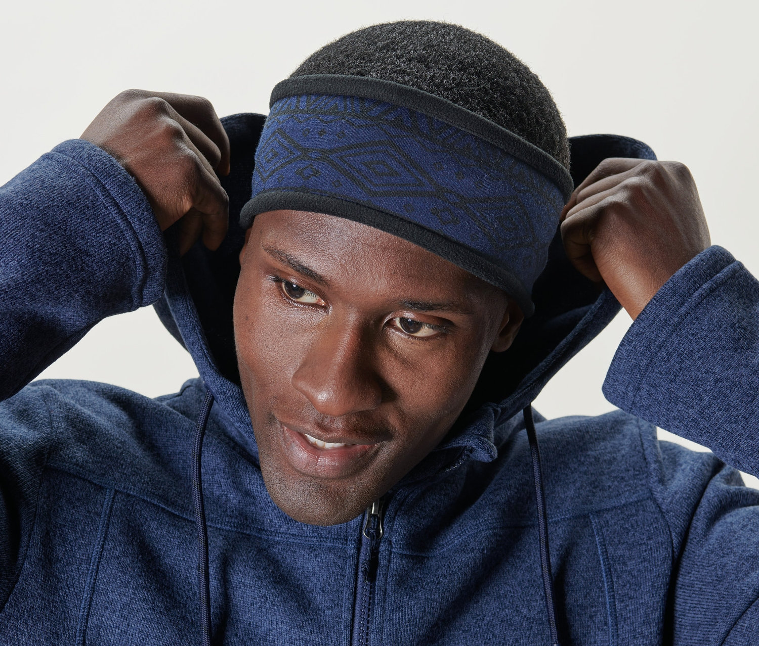 Mann setzt blaues Thermo-Fleecestirnband auf.