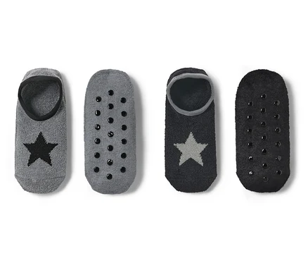 Zwei Paar Hausschuhsocken: Grau mit schwarzem Stern und Antirutschsohle und Schwarz mit silbernem Stern und Antirutschsohle.