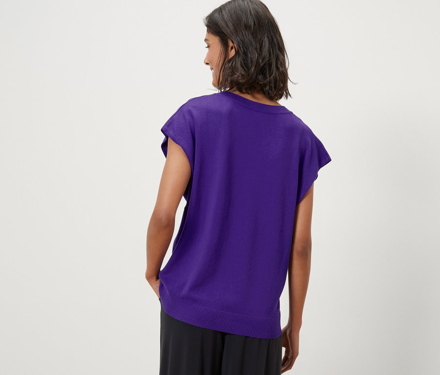 Frau trägt einen lila Kurzärmliger Feinstrickpullover.