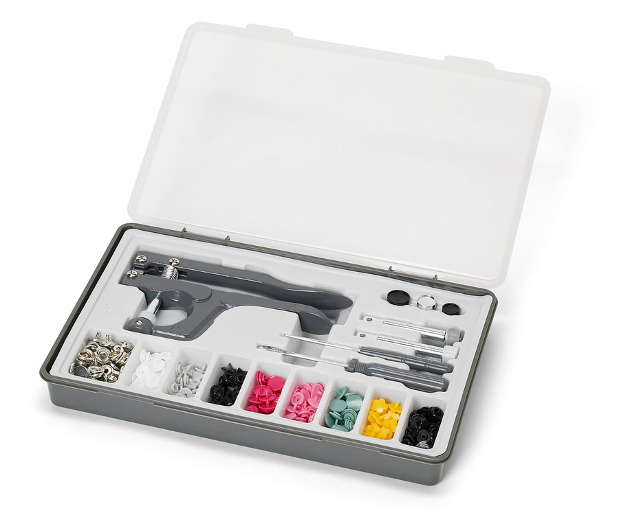 Offene graue Box mit transparentem Deckel, die ein Druckknopf-Set enthält.