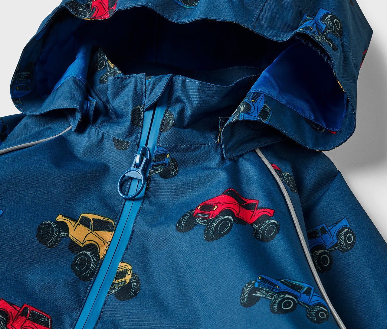 Detailansicht einer Kinder-Thermo-Regenjacke mit Monstertruck-Print.