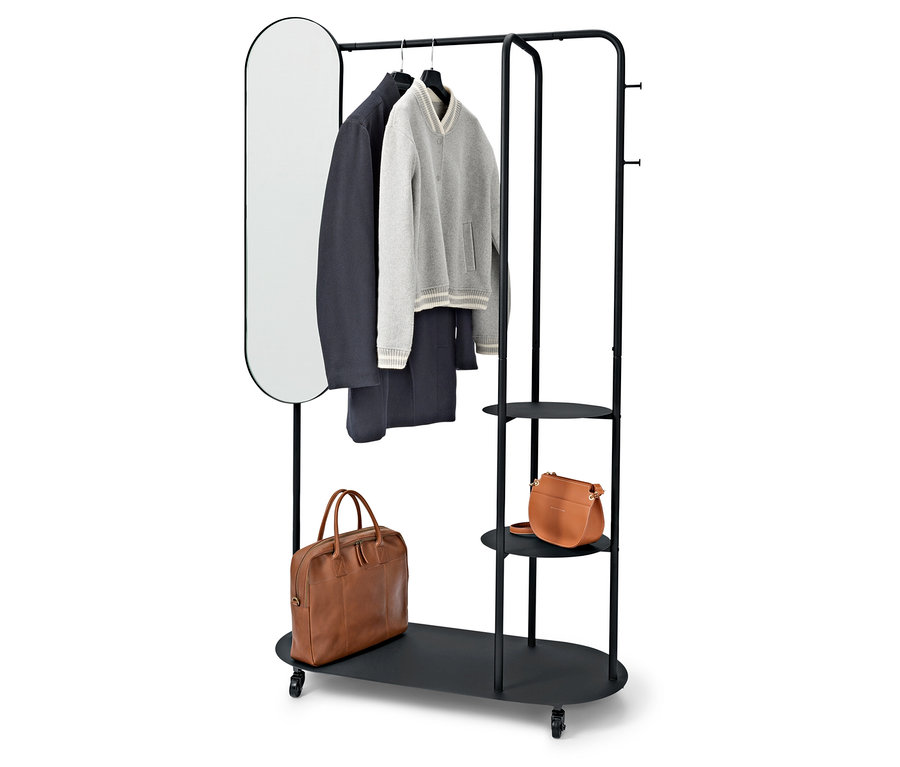Schwarzer Kleiderständer mit ovalem Spiegel, Mantel, Pullover, Hose und zwei braunen Taschen.