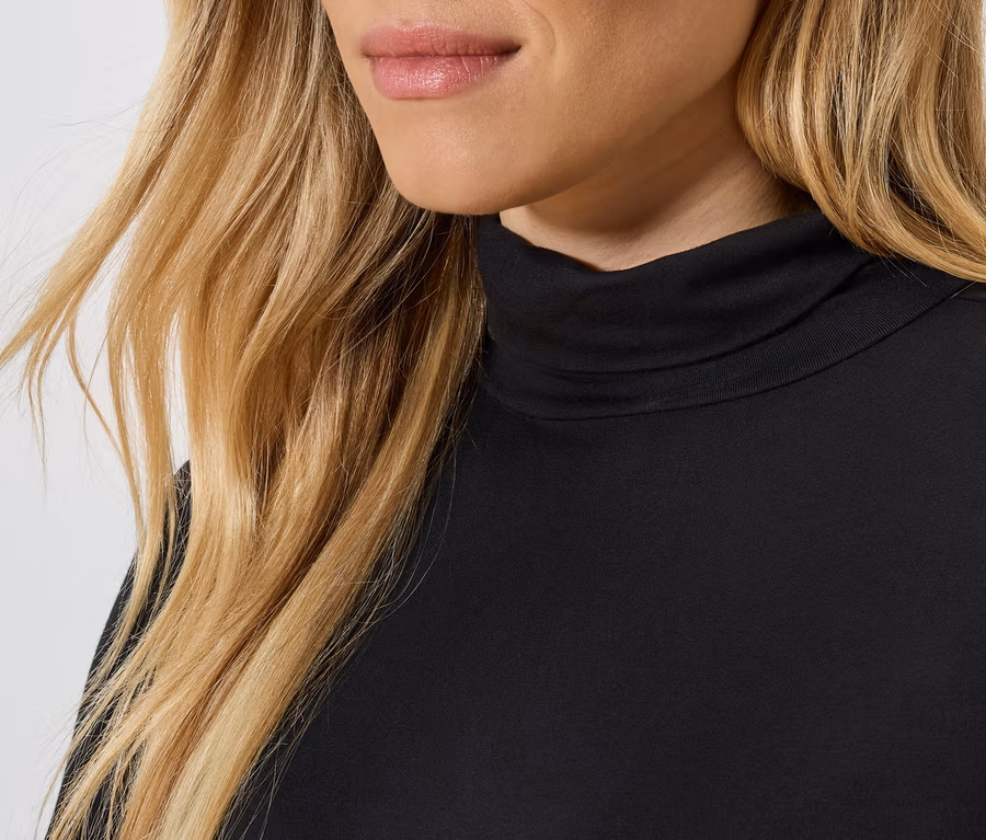 Detailaufnahme einer blonden Dame mit schwarzem Rollkragenpullover.