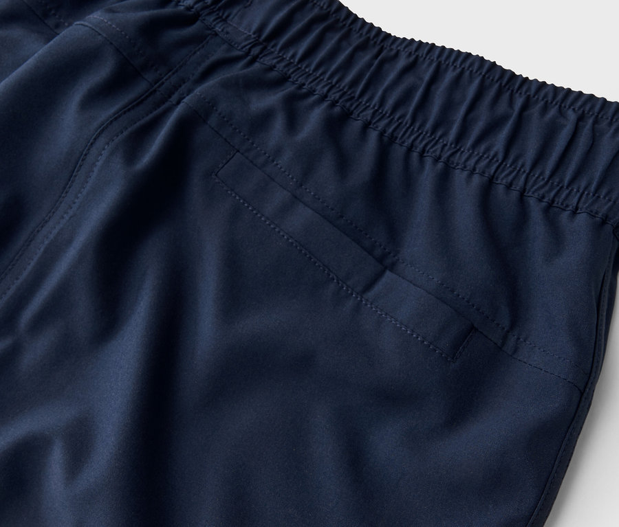 Detailaufnahme einer marineblauen Hose mit elastischem Bund und Gesäßtasche.