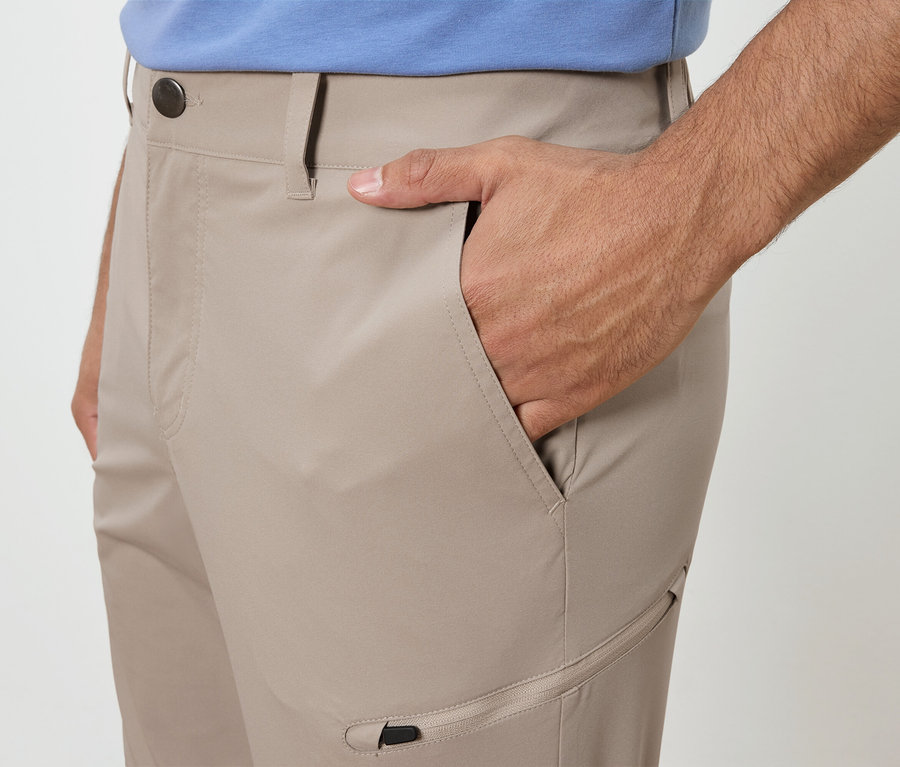 Mann mit Hand in der Tasche einer beigen Hose.
