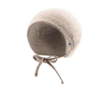 Beigefarbene Babymütze mit Ohrenklappen und Bindebändern, mit einem kleinen Logo an der Seite.