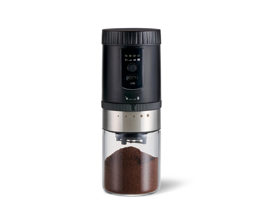Akku-Kaffeemühle in Schwarz und Silber mit transparentem Glasbehälter, gefüllt mit dunkelbraunem Kaffeepulver.