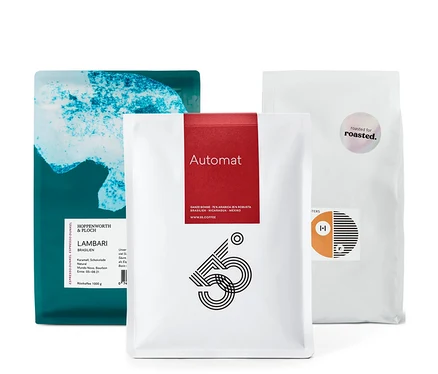 Drei Kaffeepackungen, darunter eine Packung Espresso Probierset "Rundreise durch Südamerika" - 3x 1 kg Ganze Bohne.