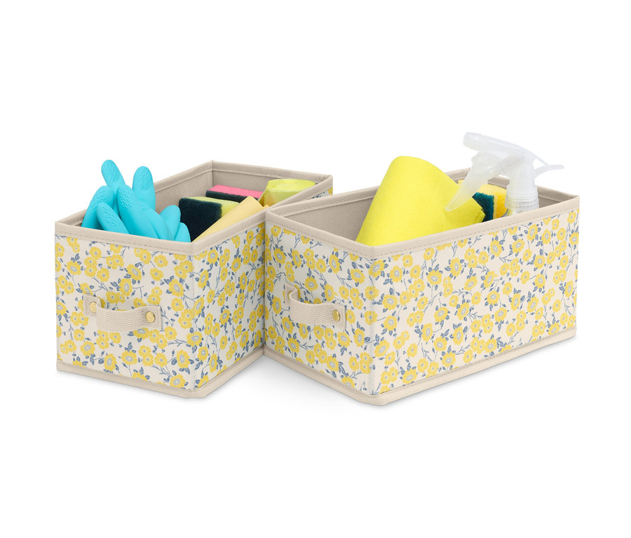 Zwei kleine Schubladen-Ordnungsboxen mit Blumenmuster, eine mit blauen Handschuhen und Schwämmen, die andere mit gelbem Lappen, Schwämmen und Spray.