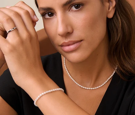 Frau trägt 925 Silber Ring Octagon, Armband Tiny Pearls und Kette.