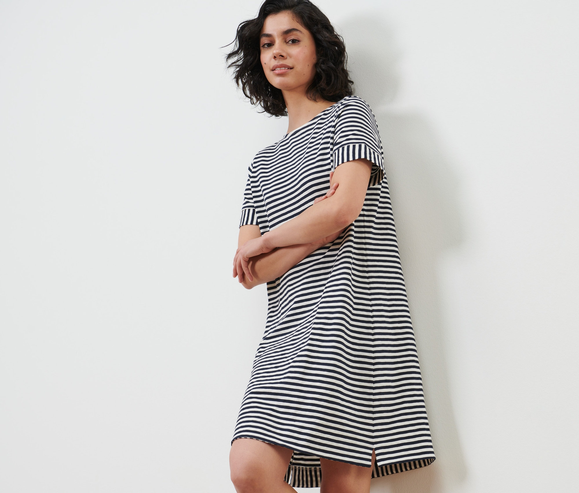 Frau posiert in einem gestreiften Jerseykleid.