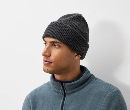 Porträt eines Mannes mit einer dunkelgrauen Strickmütze und einer blau-grauen Fleecejacke.