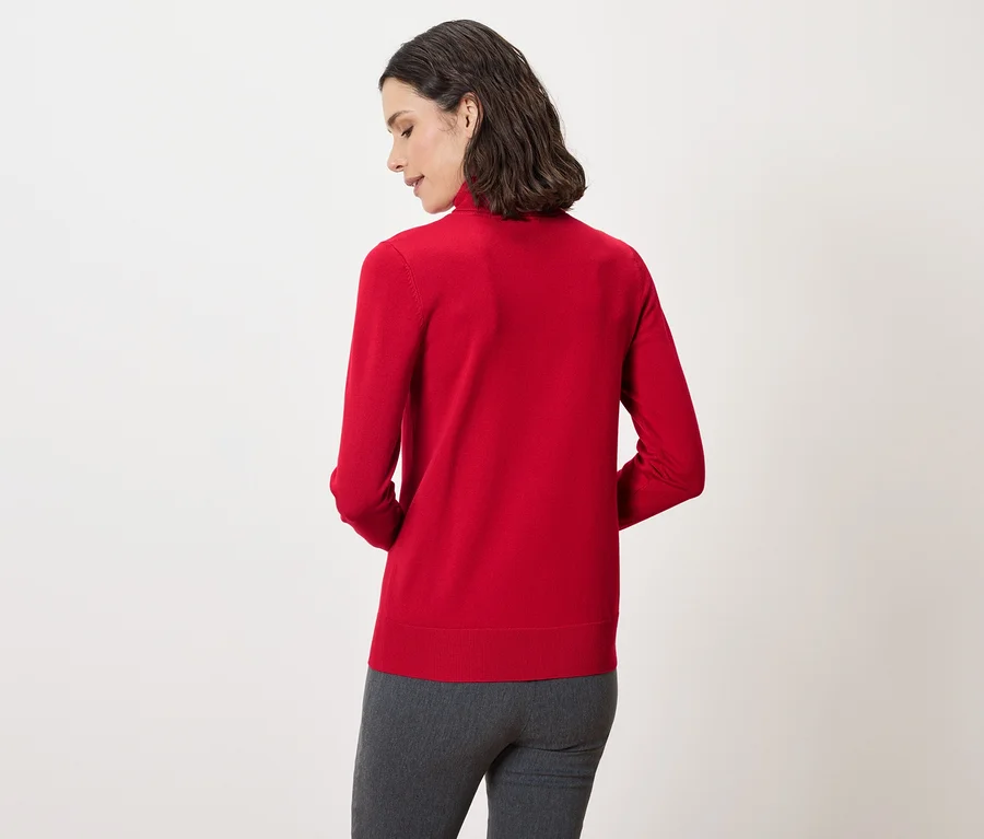 Rückansicht einer Frau mit dunklen Haaren, die einen roten Pullover und eine graue Hose trägt.
