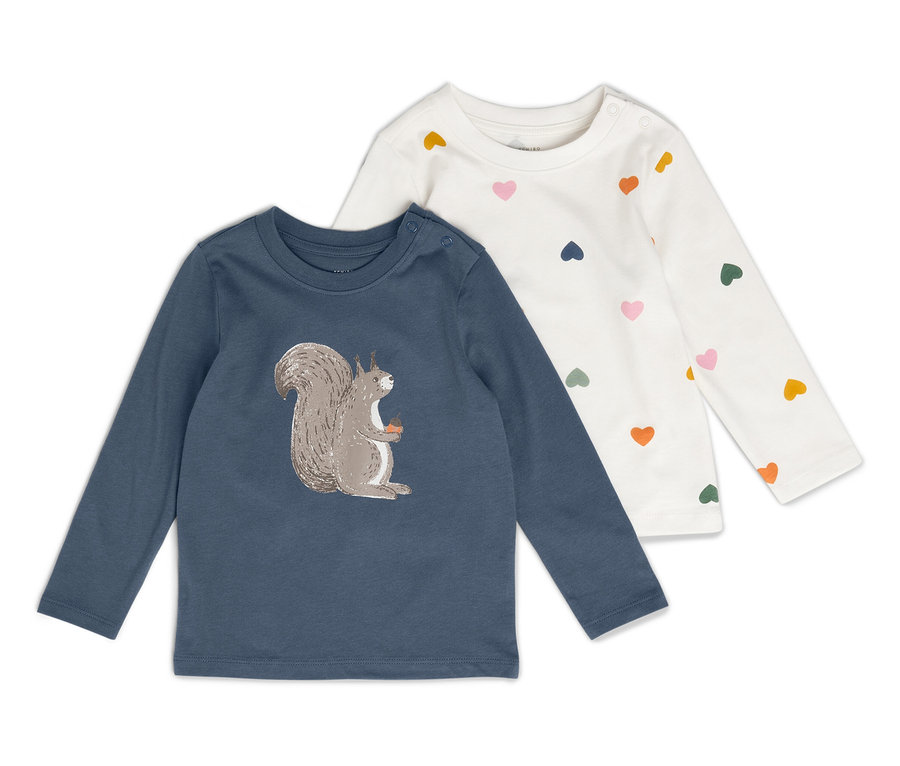 Zwei Kinderlangarmshirts liegen nebeneinander. Ein Shirt ist blau mit einem Eichhörnchenbild, das andere ist weiß mit bunten Herzen.