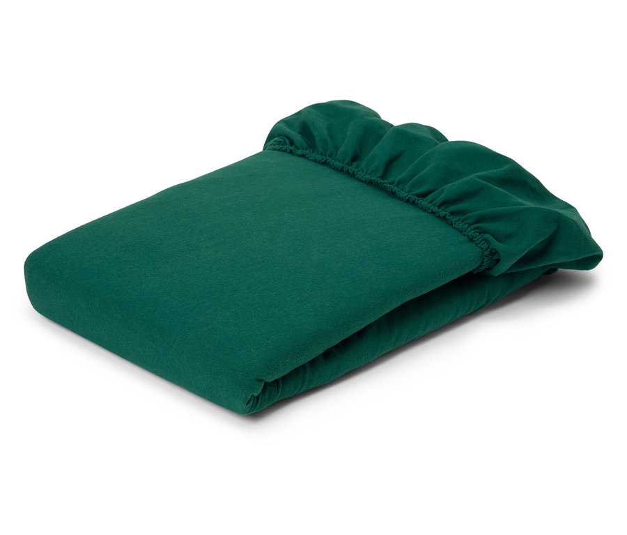 Zusammengelegtes grünes Spannbettlaken mit elastischen Ecken.