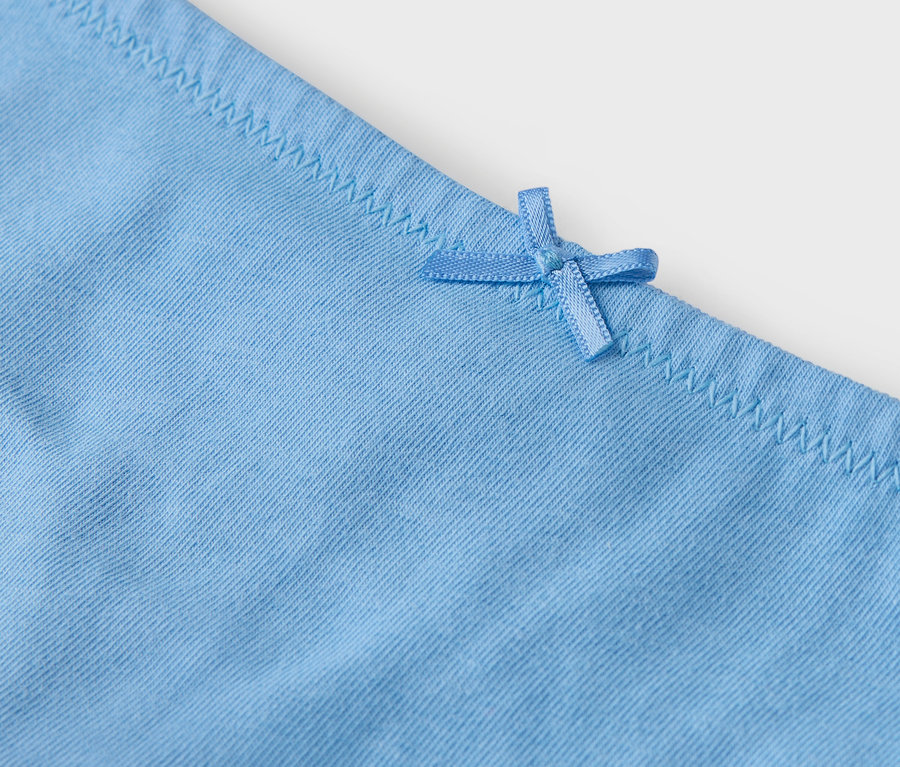 Detailansicht einer hellblauen Unterhose mit Schleife.