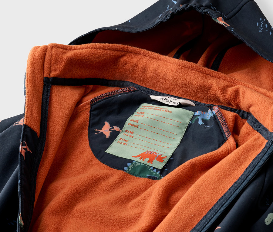 Nahaufnahme einer geöffneten, marineblauen Kinderjacke mit Dinosaurier-Muster und orangefarbenem Fleecefutter.