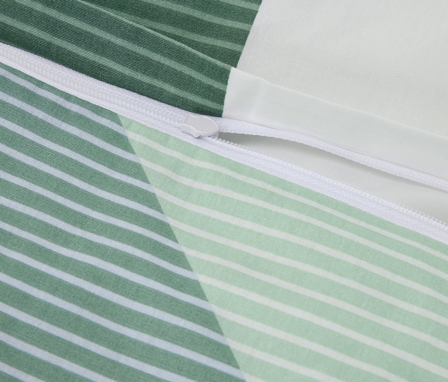 Nahaufnahme eines Bettbezugs mit grün-weiß gestreiften Mustern und einem weißen Reißverschluss.