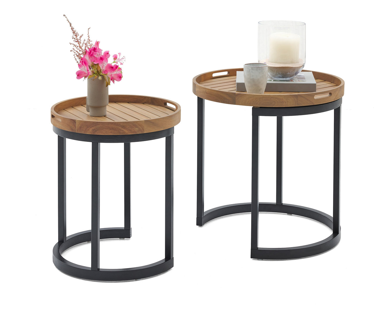 Zwei runde Beistelltische mit Holztablett und schwarzem Metallgestell. Auf dem einen Tisch steht eine Vase mit rosa Blumen, auf dem anderen eine Kerze im Glas und eine Tasse.