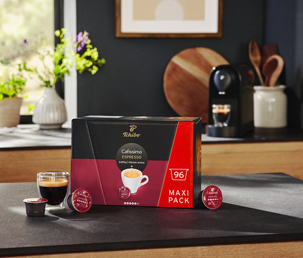 Schwarze Cafissimo pure+ und eine Packung Cafissimo Espresso kräftig - 96 Kapseln auf einer Küchentheke.