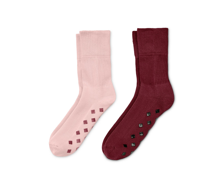 Zwei Paar Stoppersocken: ein Paar rosa, ein Paar bordeauxrot.