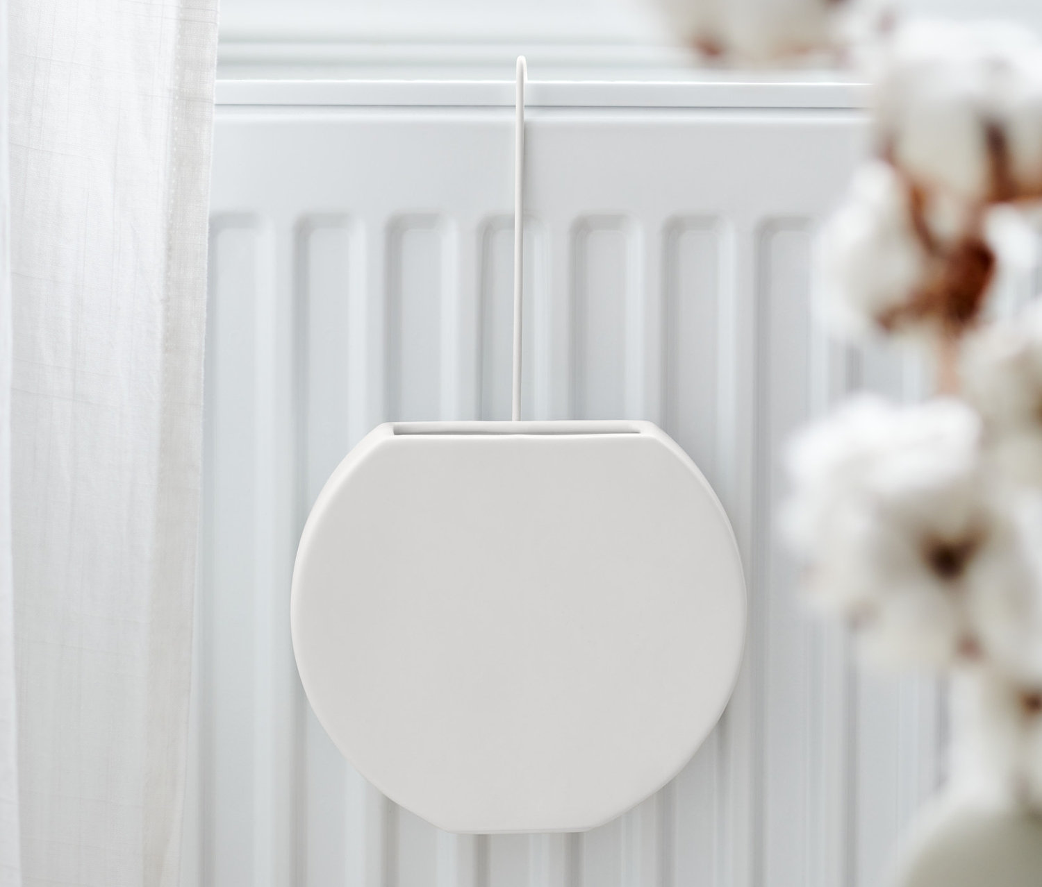 Am Heizkörper hängt ein Heizkörper-Luftbefeuchter.