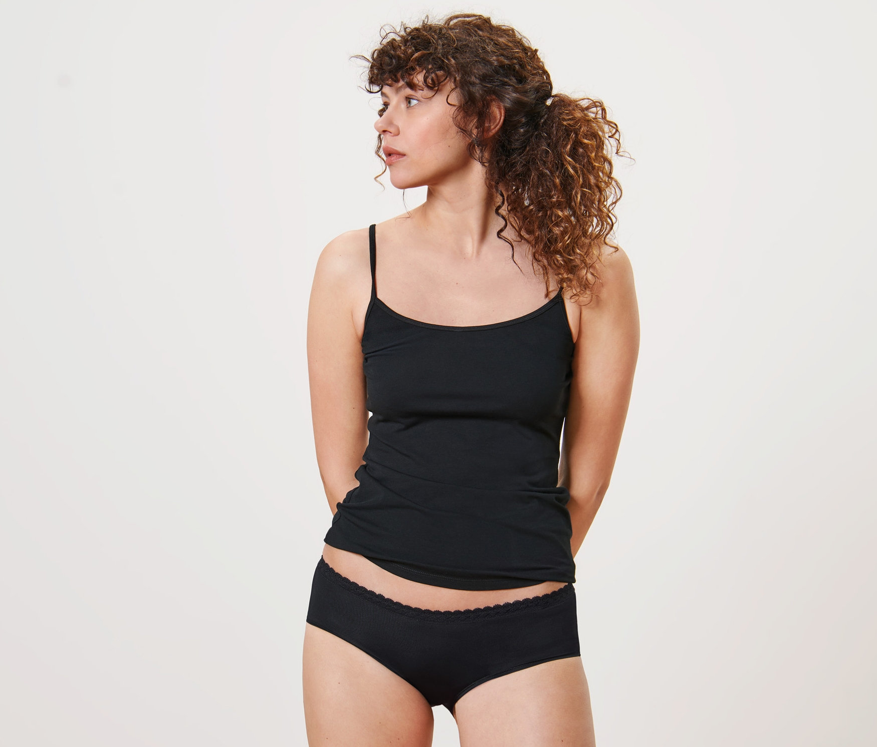 Frau trägt schwarze 5 Pantys und ein Tanktop.