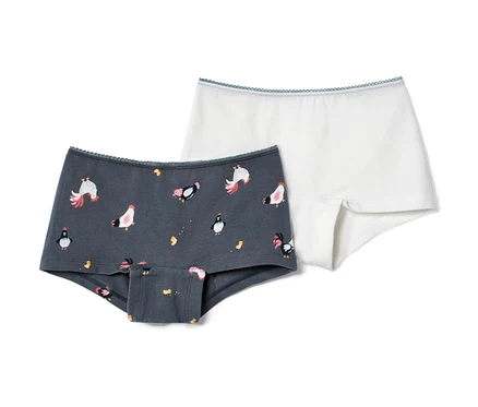 Zwei Mädchen-Pantys: eine grau mit Hühner- und Pinguinmuster, eine weiss.