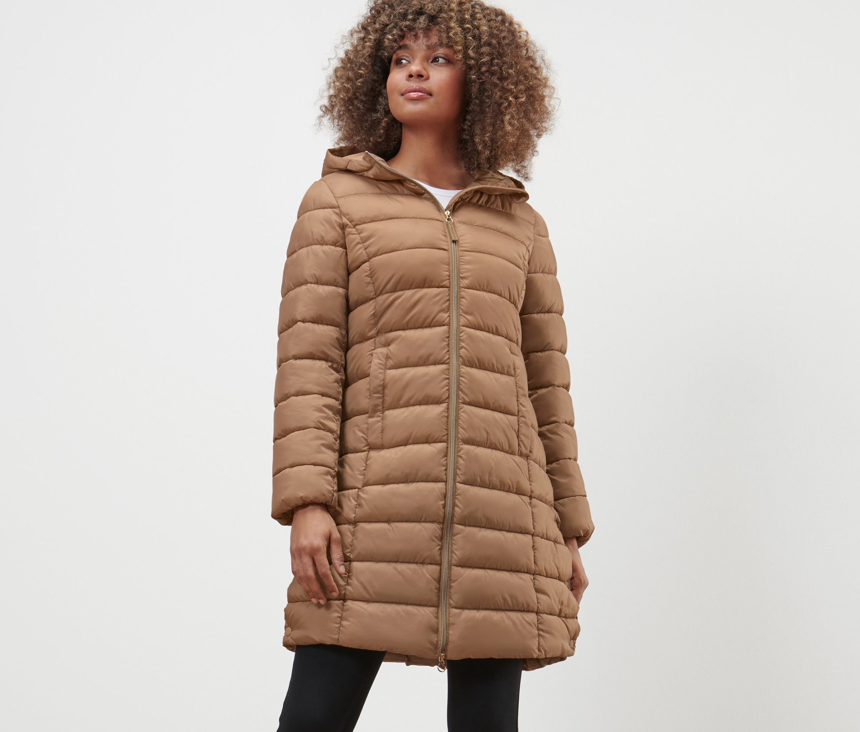 Frau trägt Steppmantel mit Kapuze.